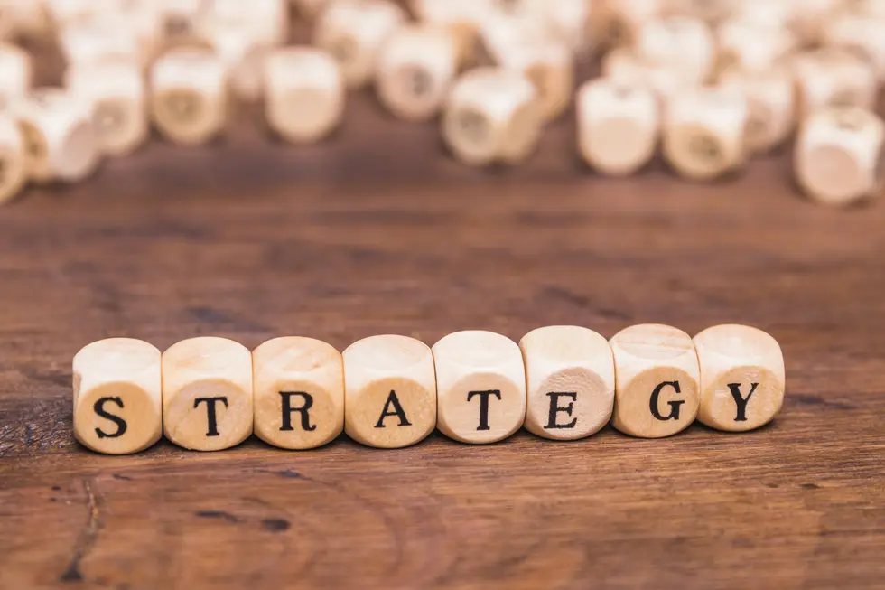 Holzperlen mit eingravierten Buchstaben bilden das Wort "STRATEGY" und liegen auf einem Holztisch. Im Hintergrund sind weitere unscharfe Holzperlen sichtbar. Der Fokus liegt auf der klaren und präzisen Darstellung des Begriffs, der häufig in geschäftlichen und strategischen Kontexten verwendet wird. Dieses Bild könnte als visuelle Unterstützung für Themen wie Planung, Entwicklung von Geschäftsstrategien oder Problemlösungsansätze dienen. Es vermittelt eine praktische Herangehensweise an strategisches Denken und Handeln.