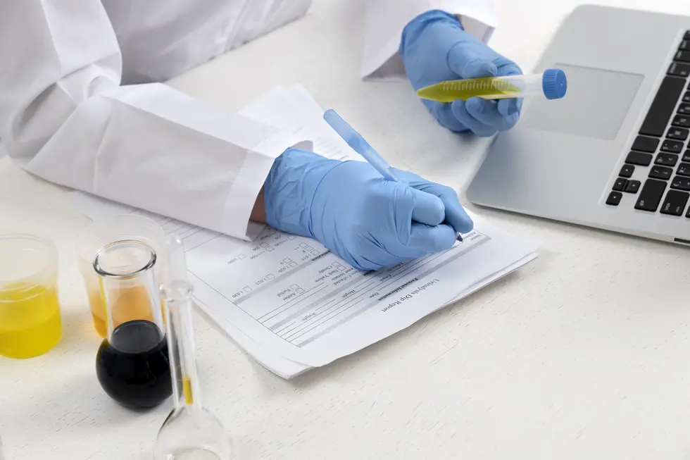 Laboruntersuchung zur Diagnostik von Dünndarmfehlbesiedlung mit einem Arzt in weißem Kittel, der Notizen macht und Proben in Reagenzgläsern vorbereitet, um Ergebnisse zu dokumentieren und eine präzise Diagnose zu stellen.