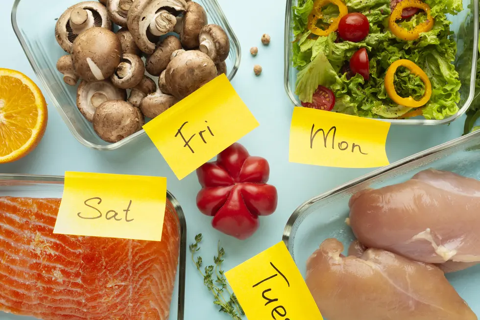 Bunte mediterrane Zutaten auf einem hellblauen Tisch, darunter frisches Gemüse wie Champignons, Paprika und Salat, Rinderfilet und Lachs, ergänzt durch eine Orange. Die Zutaten sind mit gelben Haftnotizen beschriftet, die die Wochentage (Montag, Freitag, Samstag, Dienstag) anzeigen. Diese Aufnahme vermittelt eine organisierte und gesunde Ernährung, geeignet für die Planung von Mahlzeiten bei Insulinresistenz.